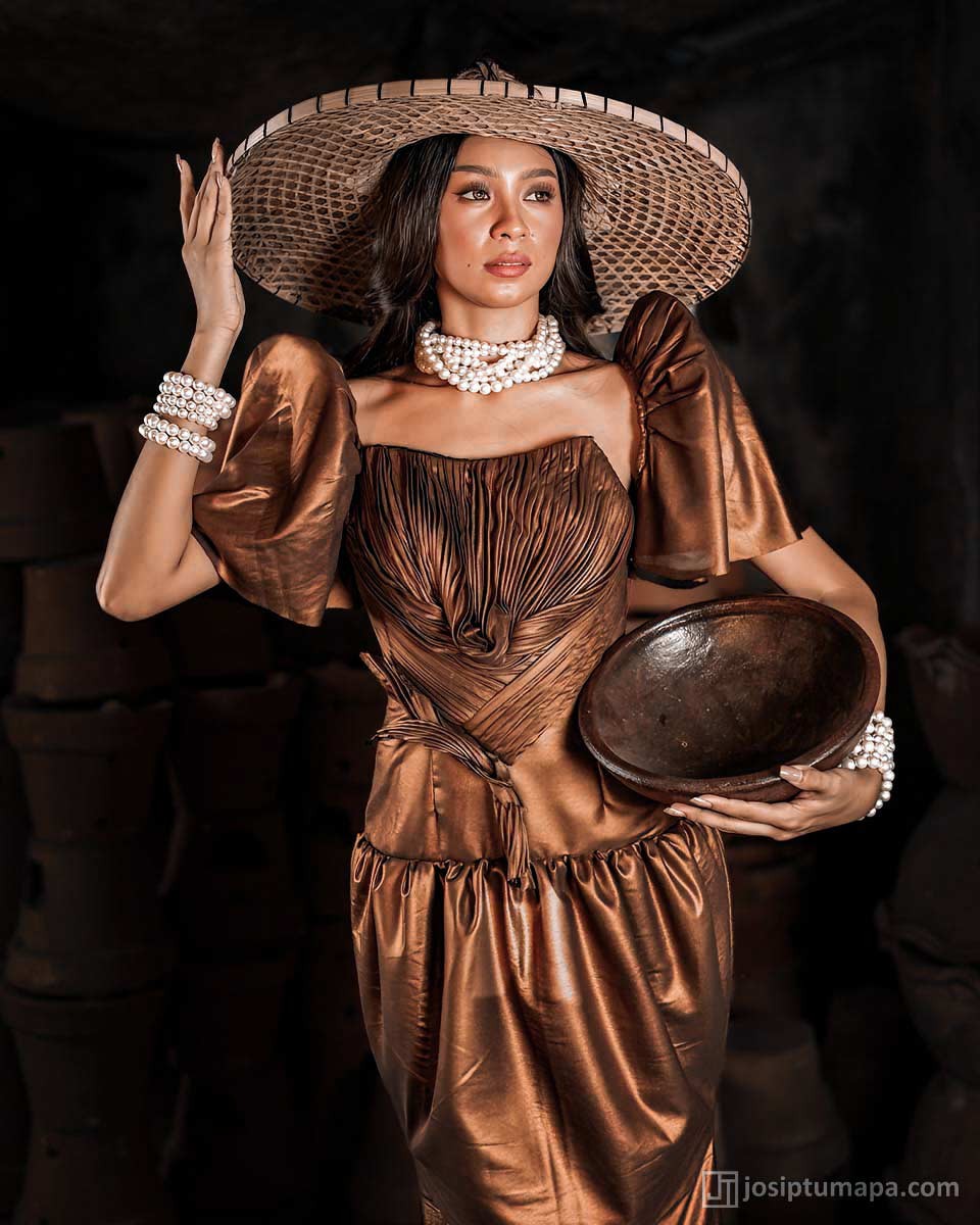 Bronzed Terno dress with sculpted pleats, wide hat, and pearl accessories